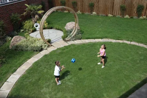 brother and sister playing with a blue football in the garden
