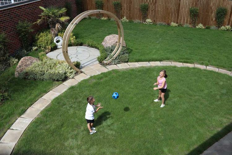 brother and sister playing with a blue football in the garden