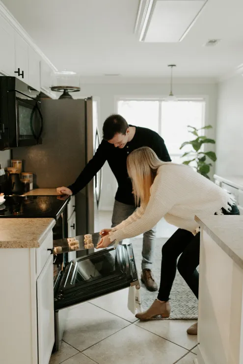 Two young people look how to use an oven