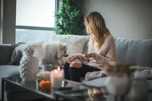 Young woman sat on the sofa with her dog
